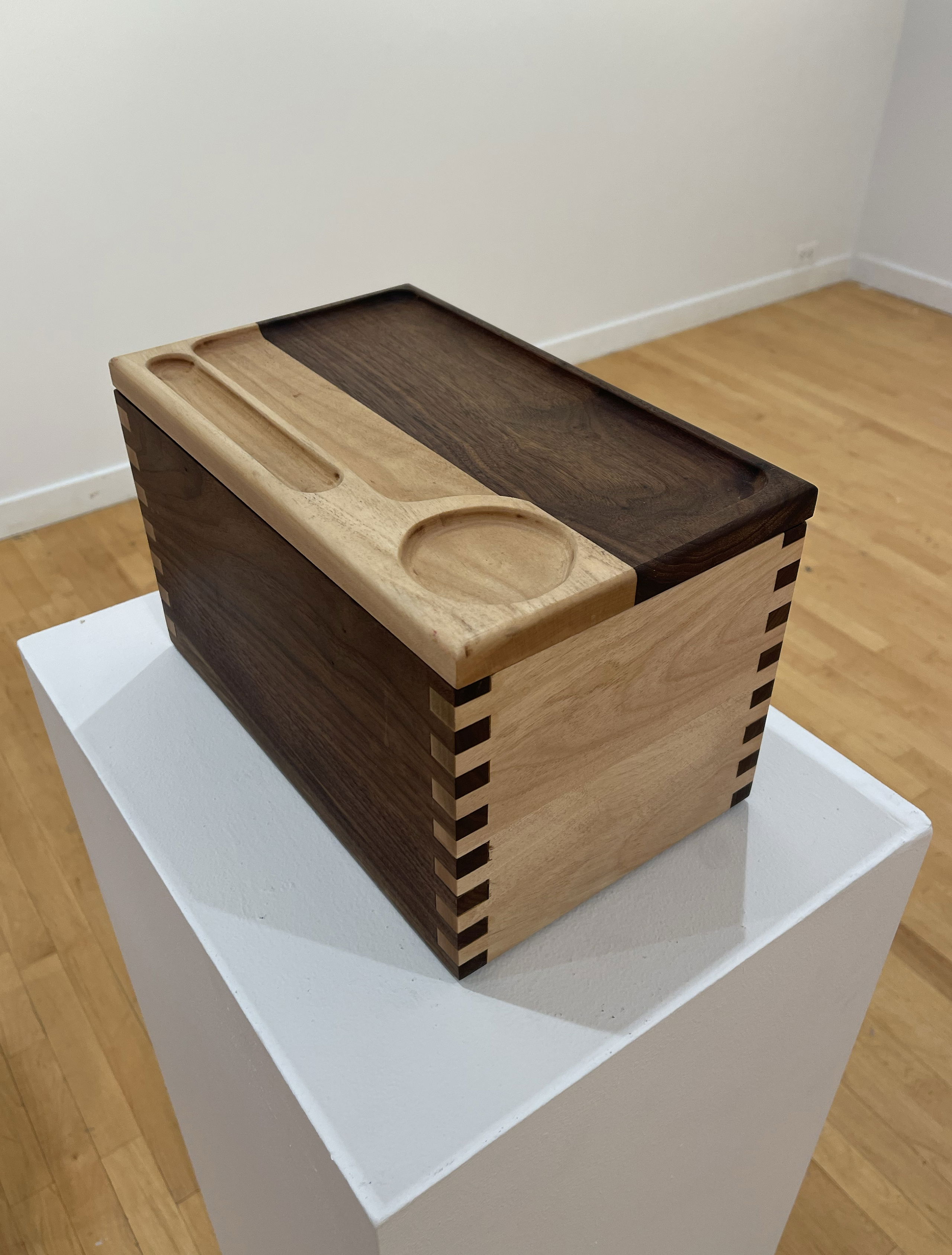 Wooden box on display in a gallery.