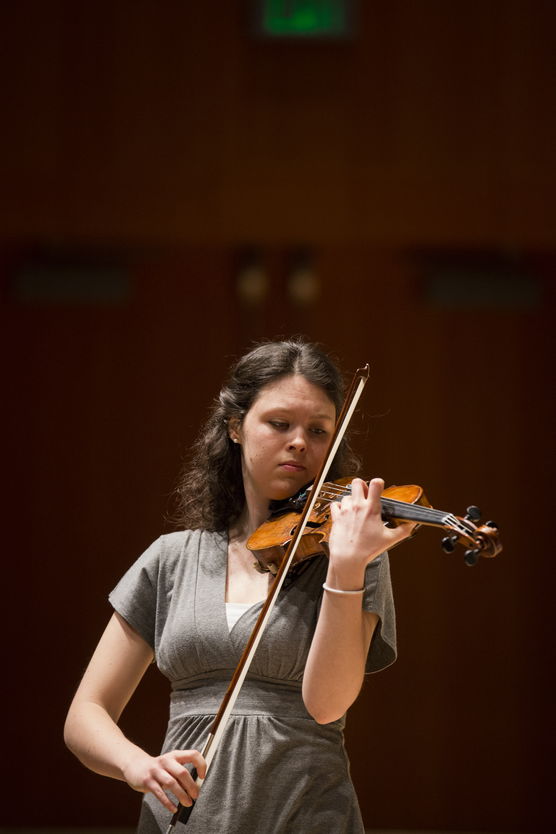 Woman playing a violin indoors.