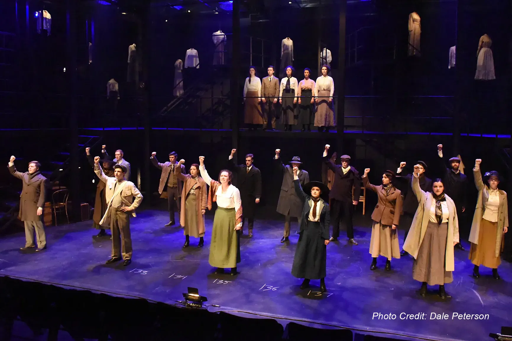 A group of performers with their fists raised in a performance