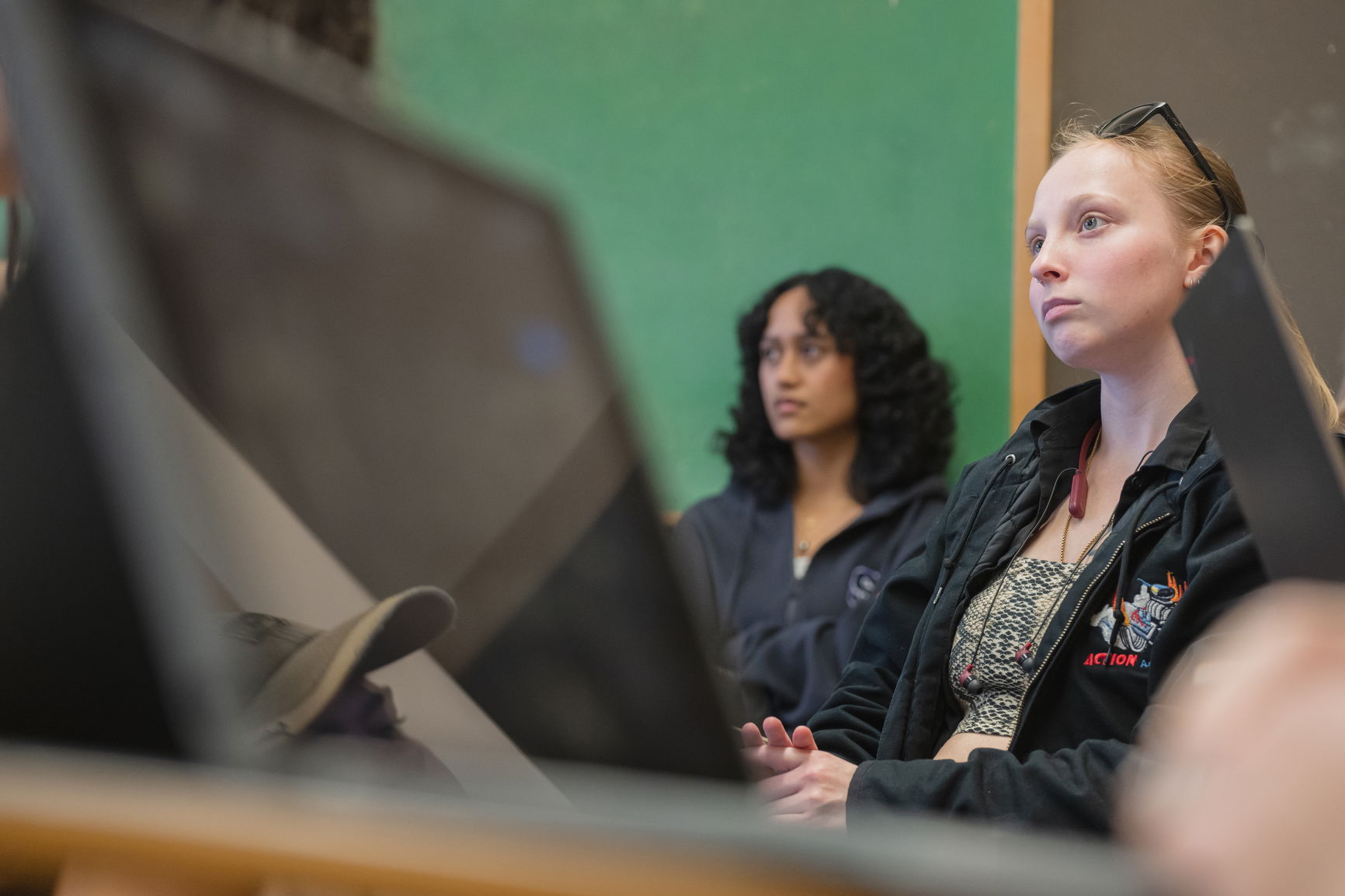 Two young women looking forward in a classroom